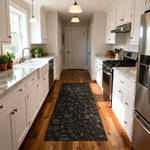 Modern kitchen with a black patterned rug on wooden flooring