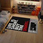 Room with a rug featuring 'Life is Short, Buy the SNKRS' text and a shoe rack.

