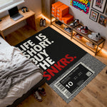 Room with a black rug featuring 'Life is short, buy the SNKRS' text and sneaker-themed decor.

