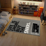 Room with a rug featuring 'Life is Short, Buy the Sneakers' text and shoe display.

