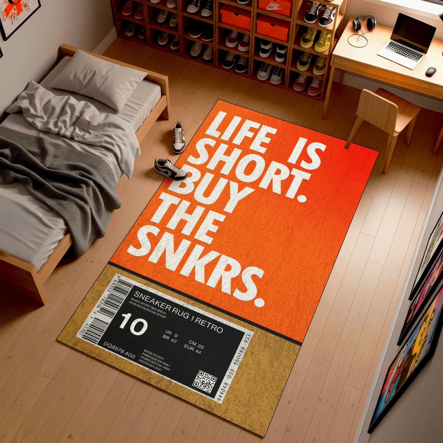 Orange rug with 'Life is Short, Buy the Snkrs' text in a room with a bed and desk.

