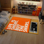 Shoe rack with various shoes in a room featuring an orange rug with text.

