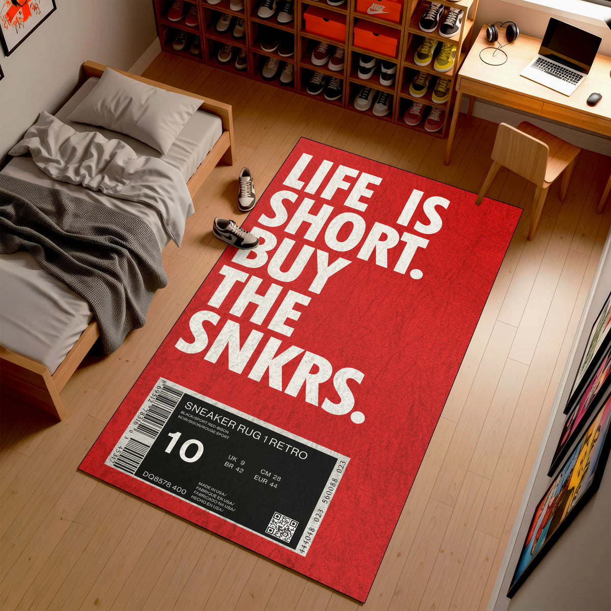 Red rug with 'Life is Short, Buy the Snkrs' text in a room with a bed and desk.

