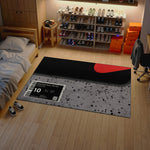 Room with a large rug featuring a sneaker brand logo, shoes on shelves, and a bed.

