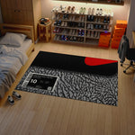 Room with a sneaker display, bed, and rug with a brand label.

