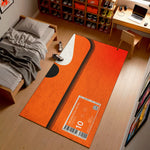 Orange rug with a barcode design on a wooden floor in a room with a bed and desk.

