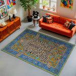 Living room with an orange sofa, colorful rug, and decorative items.