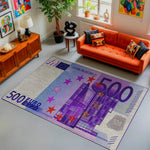 Living room with a colorful rug featuring a €500 banknote design, orange sofa, and decorative items.


