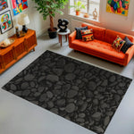 Living room with an orange sofa, black patterned rug, and decorative items.