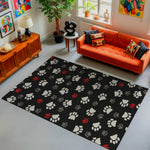 Living room with an orange sofa, colorful pillows, and a black rug with paw prints.