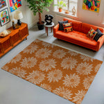 Living room with an orange sofa, patterned rug, and decorative items.