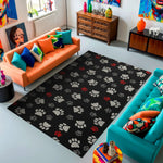 Living room with a black rug featuring paw prints, colorful couches, and decorative items.